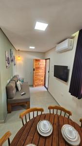 un salon avec une table, des chaises et un canapé dans l'établissement Casas Costa Dos Corais, à Japaratinga