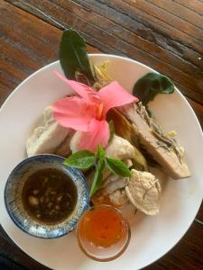 ein Teller mit Essen und einer rosa Blume darauf in der Unterkunft Battambang Eco Stay &cooking class in Battambang