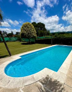 una piscina con acqua blu in un cortile di Cabaña a Vaqueros