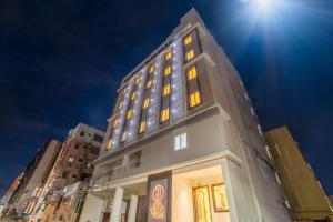 a tall building with yellow lights on it at Hotel Helixo Classic Kompally in Hyderabad