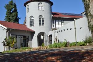 a white church with a tower on a street at Eeufees Guesthouse in Bloemfontein