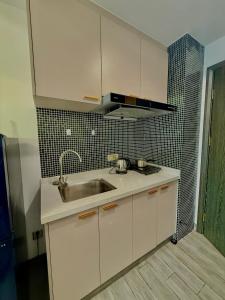 una cucina con armadi bianchi, lavandino e piastrelle nere di SB Condo Sihanoukville -700m To U MALL a Sihanoukville Altre 29 foto