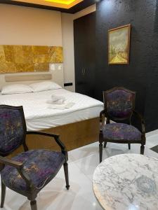 una camera da letto con un letto, due sedie e un tavolo di Paradise 7Palace a Istanbul