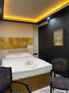 una camera da letto con un letto con due sedie e un paravento di Paradise 7Palace a Istanbul