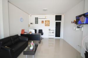 a living room with a couch and a table at JC Guesthouse @ Suratthani Airport in Surat Thani