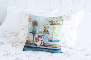 马莱尼White Jacaranda Tiny House by Tiny Away的床上摆放着几只花瓶，旁边放着一个枕头。