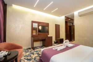 a hotel room with a bed and a tv at فندق جوهرة المقام الحمراء in Jeddah