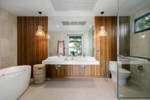 a bathroom with a tub and a sink and a toilet at 班塔莱海滨之家1号 in Koh Samui +66 photos