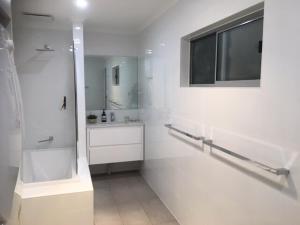 a white bathroom with a shower and a sink at Maylands Cottage in Evandale +9 photos