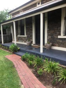 a porch of a house with plants on it at Maylands Cottage in Evandale