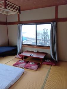 Un dormitorio con una cama y una ventana con alfombras rojas. en 白浜の宿梅 別館, en Shirahama