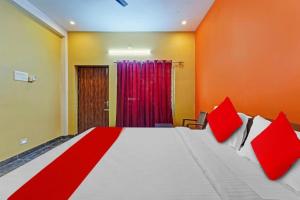 a bedroom with a large bed with red pillows at Jardin Paradise in Puducherry