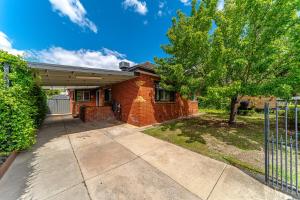 una casa de ladrillo con garaje y valla en 5min to CBD and Sleeps 9 with Spa and EV charger, en Quarry Hill