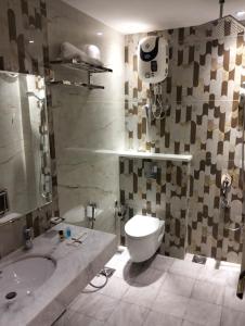 a bathroom with a sink and a toilet and a tub at Dimora Hotel Anarkali in Lahore +22 photos