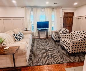 een woonkamer met een bank, stoelen en een televisie bij Cozy 3BR Cottage with Firepit Sleeps 10 Close to Lake Fun in Scottsboro