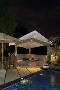 UluwatuVilla Pangkung的坐在游泳池旁的伞下的人 更多8张照片
