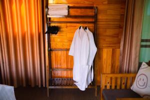 a white robe hanging on a wooden wall at Hidden Valley Eco Retreat Trang An in Ninh Binh +22 photos