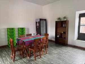 een eetkamer met een tafel met stoelen en groene muren bij Old House Hostel in Sucre +20 foto's