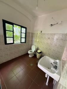 een badkamer met een witte wastafel en een toilet bij Old House Hostel in Sucre