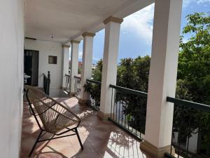 een balkon van een huis met een stoel bij Old House Hostel in Sucre