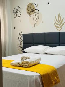 un letto con coperta gialla e asciugamani di Apartamento novo e confortável, até 8 pessoas - Pague com cartão de crédito a Belém Altre 35 foto