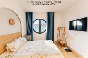 a bedroom with a bed and a round window at Khách Sạn MINTNACIE in Phan Rang–Tháp Chàm
