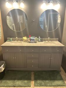 un baño con dos lavabos y dos espejos en Bannock Manor, en Memphis