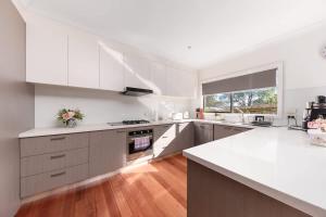 a kitchen with white cabinets and a white counter top at Welcome home Burwood in Burwood