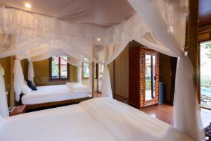 una camera da letto con un letto a baldacchino di Lotus Field Homestay a Ninh Binh Altre 129 foto
