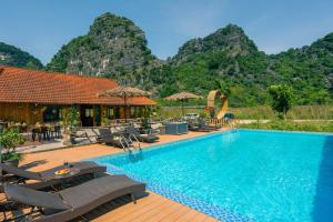 una piscina in un resort con montagne sullo sfondo di Lotus Field Homestay a Ninh Binh