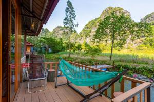 un'amaca su una terrazza con montagne sullo sfondo di Lotus Field Homestay a Ninh Binh