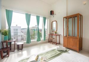 una camera da letto con un letto e una grande finestra di Lu Tan Residence a Da Lat