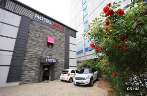 Dos coches blancos estacionados frente a un edificio en KANU hotel, en Seúl