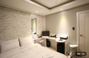 Un dormitorio con una cama y un escritorio con una computadora. en KANU hotel, en Seúl
