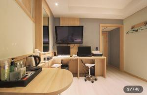 Habitación con escritorio y TV en la pared. en KANU hotel, en Seúl