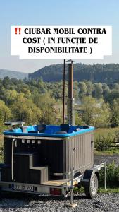 丰达塔Pensiunea Dealul Miristei Fundata的拖车后面装着一个热水浴缸。