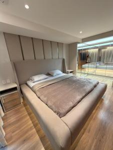 ブラジリアにあるResidencial New Yorkの大きなベッドと大きな窓のある寝室