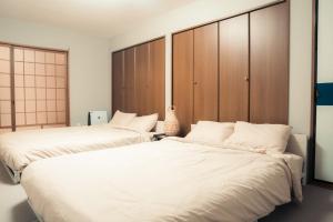 two beds sitting next to each other in a bedroom at 子連れ歓迎 平屋一棟貸し 3LDK 最大8名 プレイルーム付 法隆寺徒歩5分 HMV Horyuji in Ikaruga