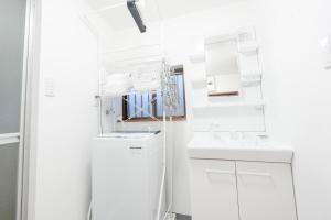 a white bathroom with a sink and a mirror at 子連れ歓迎 平屋一棟貸し 3LDK 最大8名 プレイルーム付 法隆寺徒歩5分 HMV Horyuji in Ikaruga