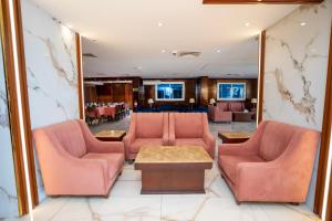 فندق جوهرة المقام الحمراء في جدة: غرفة انتظار مع كراسي وردية وطاولة