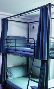 un lit superposé avec des lits superposés bleus et une échelle dans l'établissement European Hostel Central Pattaya, à Pattaya