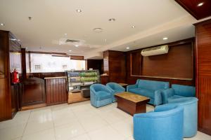 a waiting room with blue chairs and a table at فندق جوهرة المقام الحمراء in Jeddah