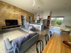a living room with a couch and a table at EcoHaven Beach Retreat in Cape Paterson