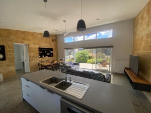 a kitchen with a sink and a living room at EcoHaven Beach Retreat in Cape Paterson +12 photos