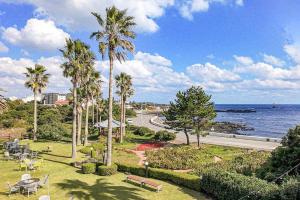 a park with palm trees and a road next to the ocean at Stay Cherry in Namwon