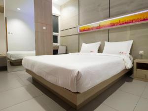 ein Schlafzimmer mit einem großen Bett mit weißer Bettwäsche in der Unterkunft Casa Living Setiabudi Jakarta in Jakarta