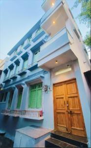a white building with a wooden door and windows at Johari Heritage Home in Ujjain