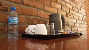 una mesa con una botella de agua y una cafetera en Sunset Retreat Hotel, en Arusha 14 fotos más