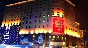 Changchun Global Hotel في تشانغتشون: مبنى يوجد أمامه برج أحمر
