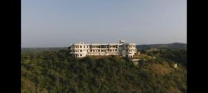 una gran casa blanca en la cima de una colina en GOVIND GARH NATHDWARa, en Nathdwara